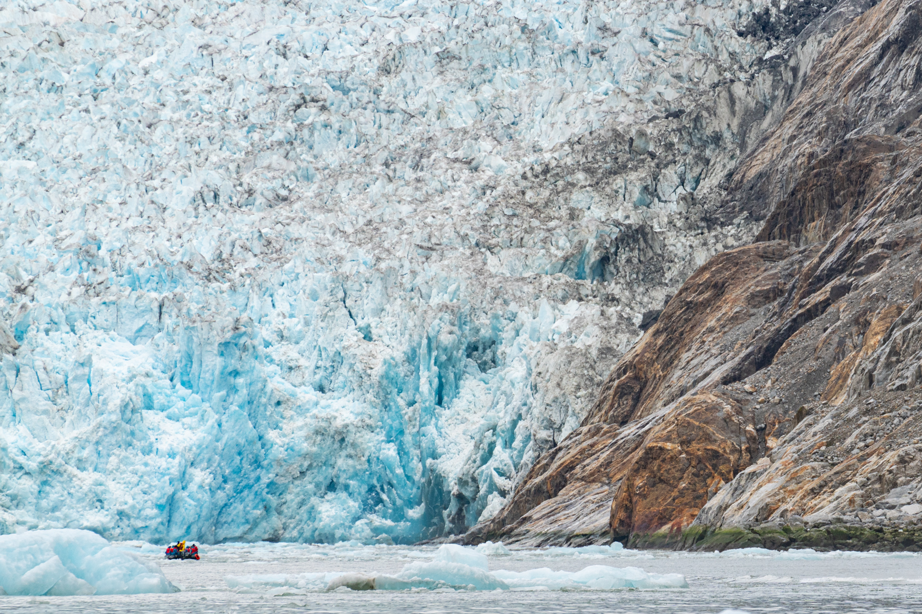 Dawes Glacier, with a Zodiac in the foreground showing the scale of it.