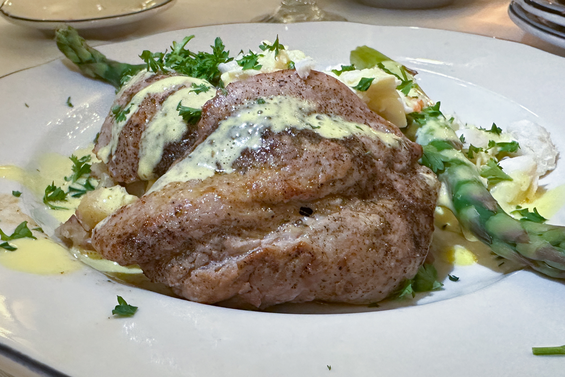 Veal cutlets with potato mash, steamed asparagus, crabmeat, and tasso Hollandaise.