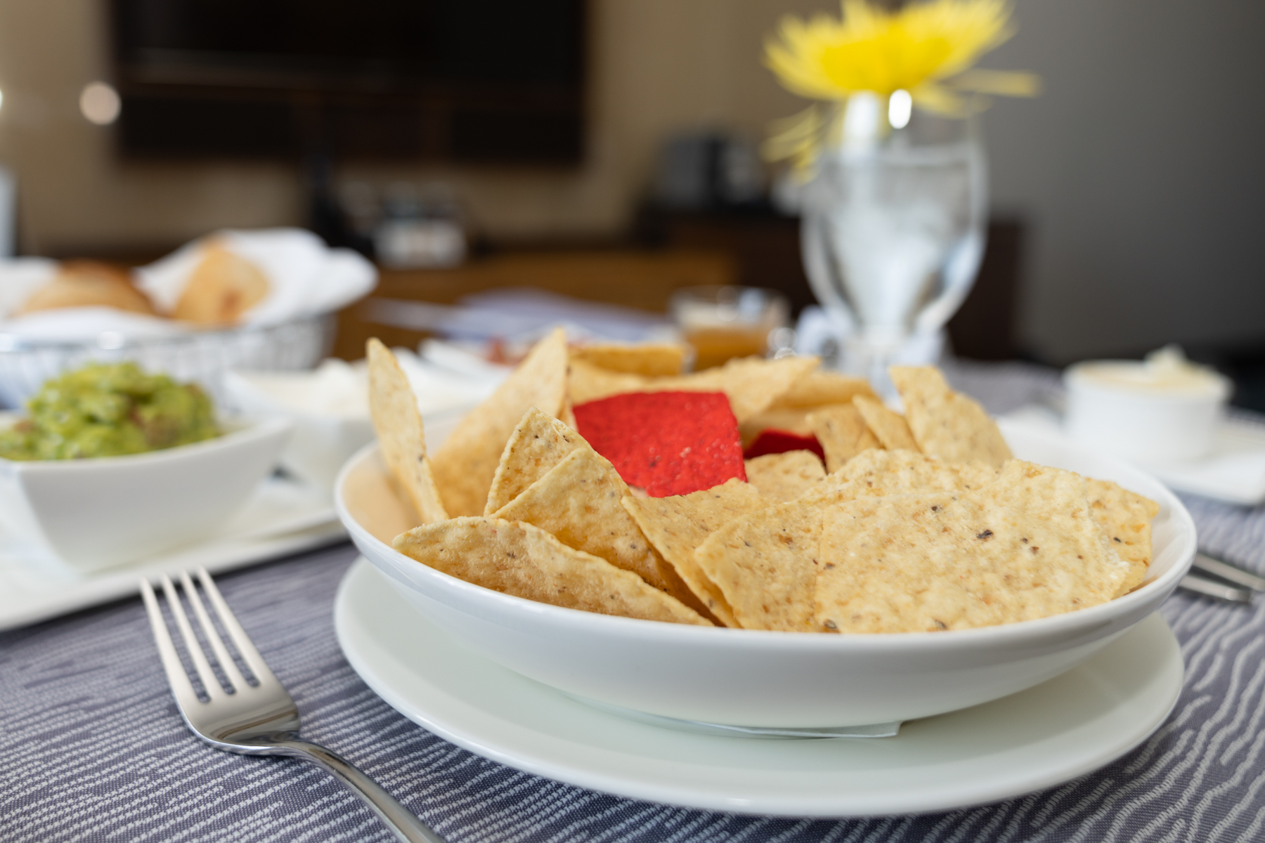 Corn chips with guacamole, sour cream, and salsa.