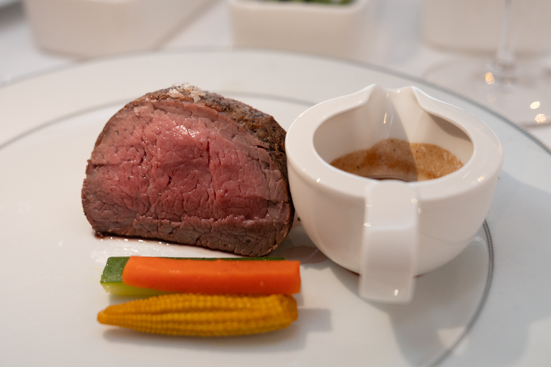 Rossini-style beef tenderloin with Perigordine sauce, baby vegetables, and brioche crouton.