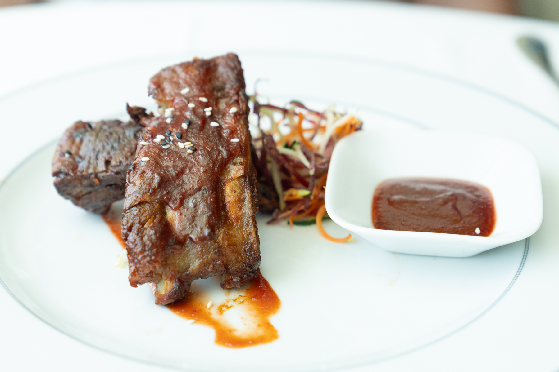 Barbecue pork ribs with char siu sauce and sesame seeds.