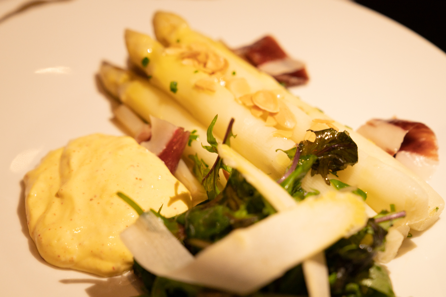 White asparagus with lemon hollandaise, almond, and Ibérico ham.