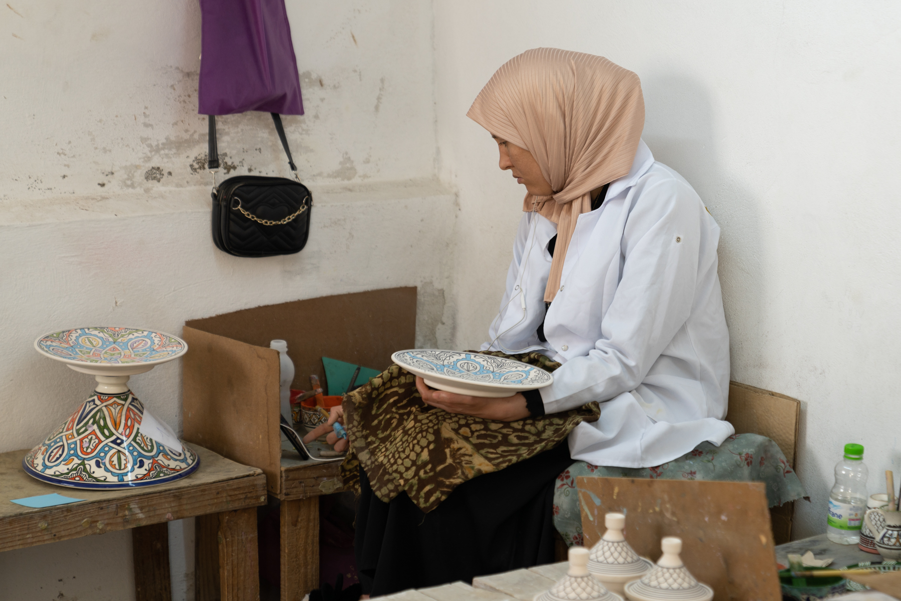 A worker painting a plate.