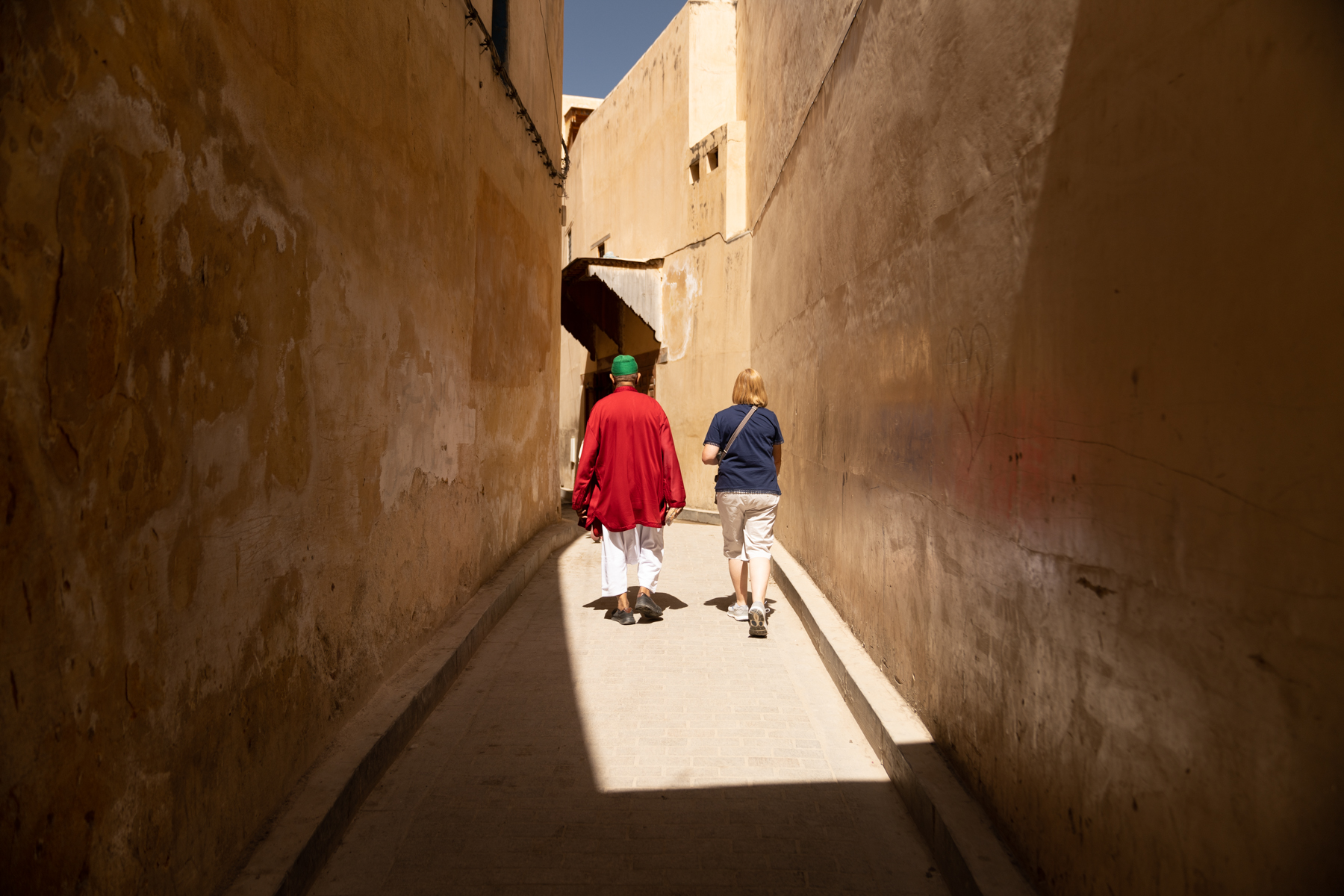 Mohamed and Andrea walking down an alley.