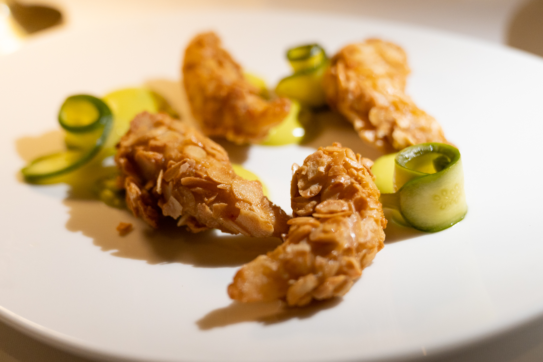 Almond-encrusted prawns with pickled cucumber in saffron and parsley mayonnaise.