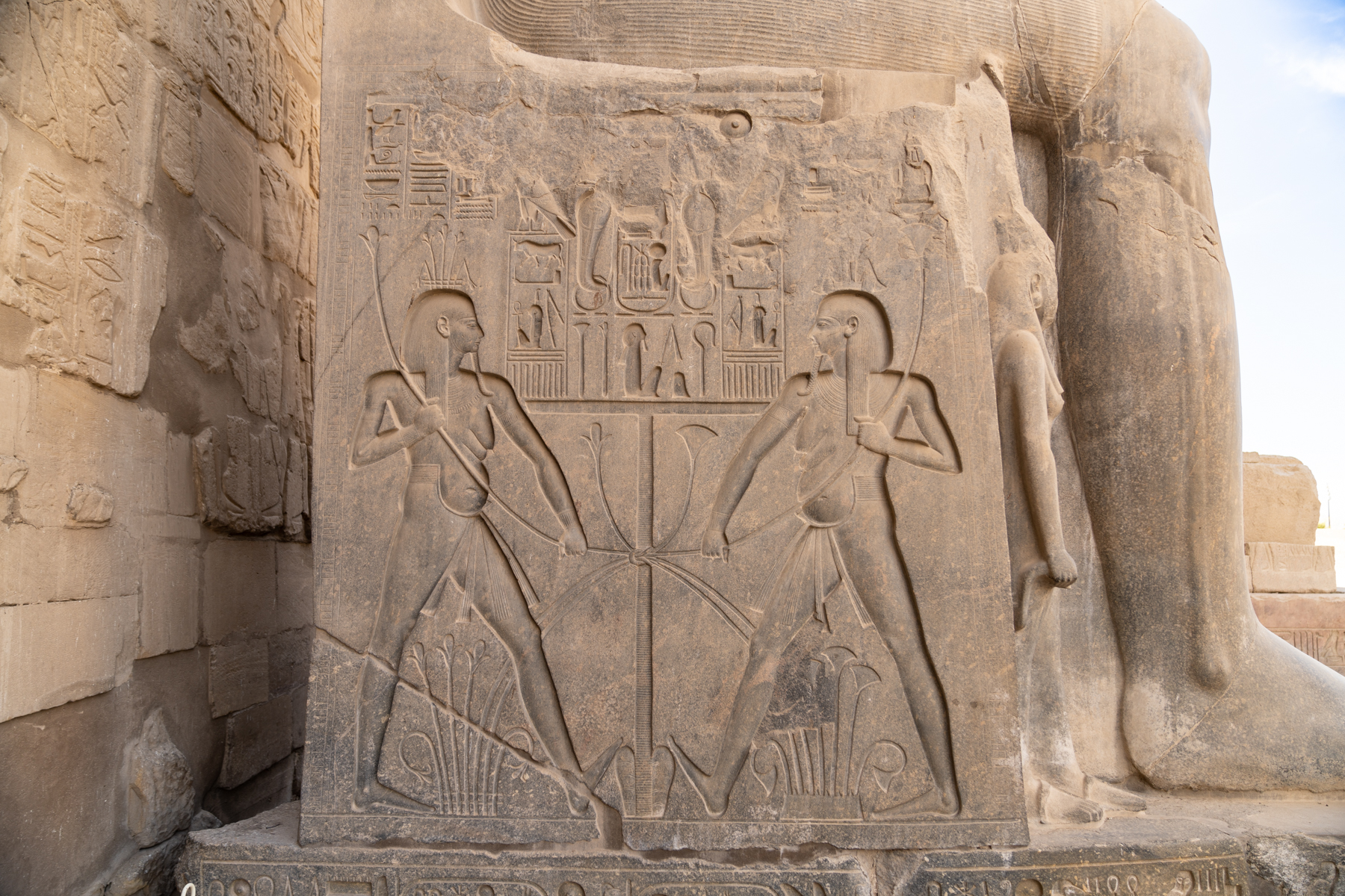 Artwork on the foundation of the statue of Rameses II at the entrance to the Luxor Temple.