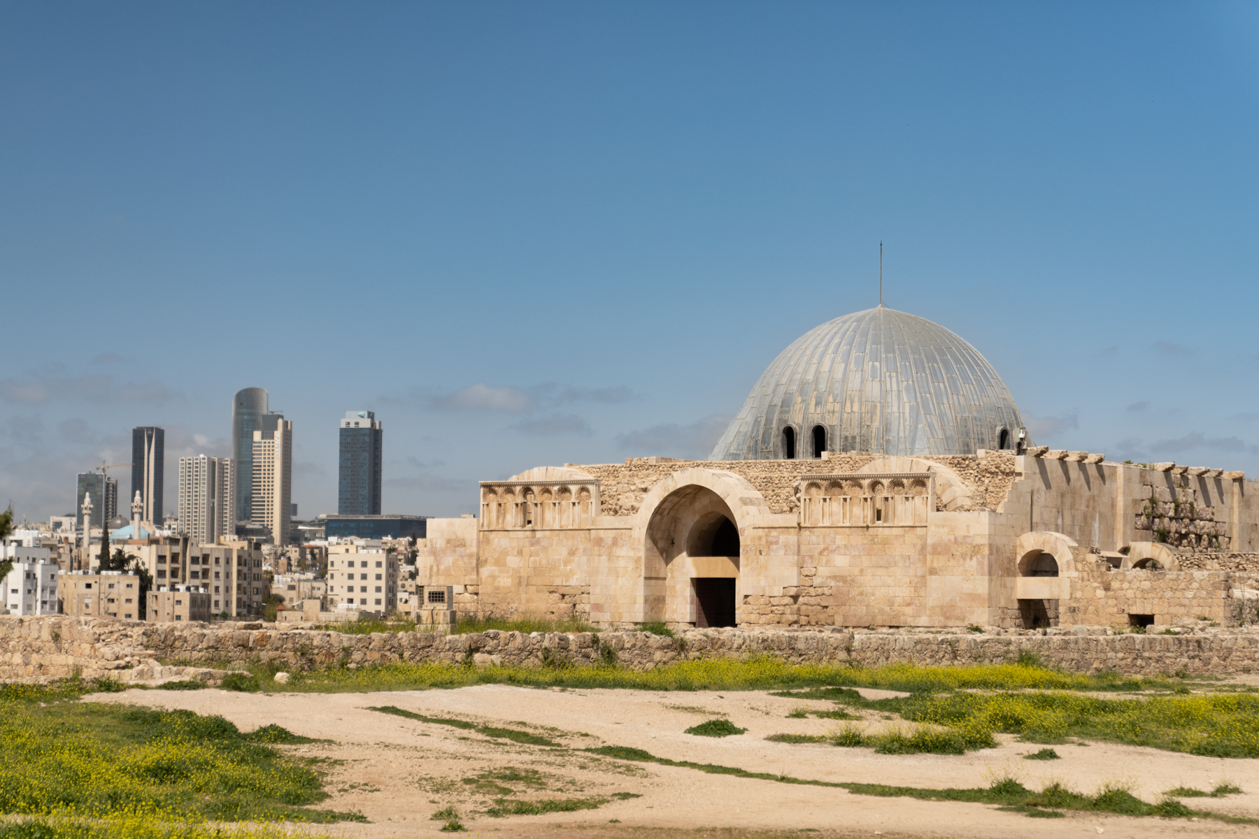 The monumental gateway to the 8th century Umayyad Palace (with a restored domed entrance chamber) and modern Amman in the background.