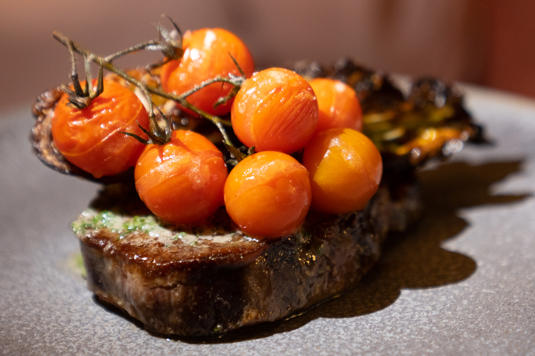 Ribeye steak with charred Hispi cabbage, Café de Paris butter, and vine tomatoes.