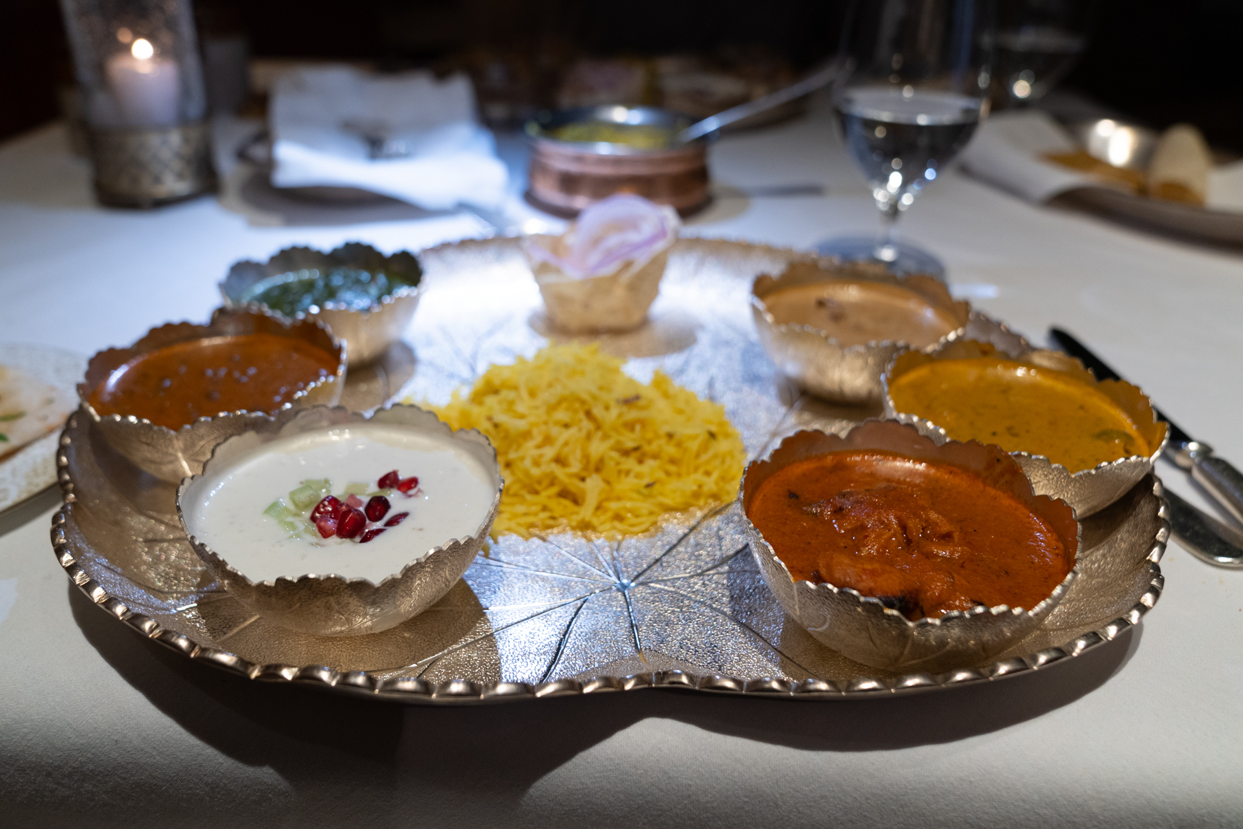 Bengal fish curry, butter chicken, lamb slow-cooked with ginger and cardamon, cottage cheese braised with lotus seeds, and black lentils simmered with tomatoes and pomegranate juice.