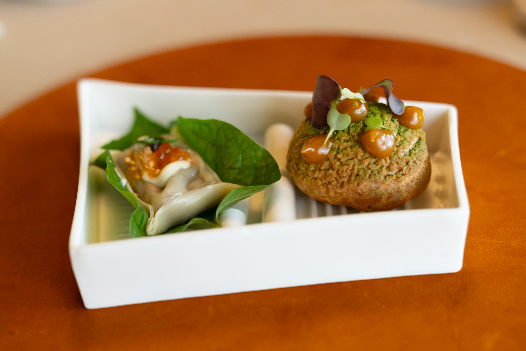 Dumpling of smoked salmon, horseradish, betel leaf, with gougere of Coronation chicken, apricot jam, chervil.