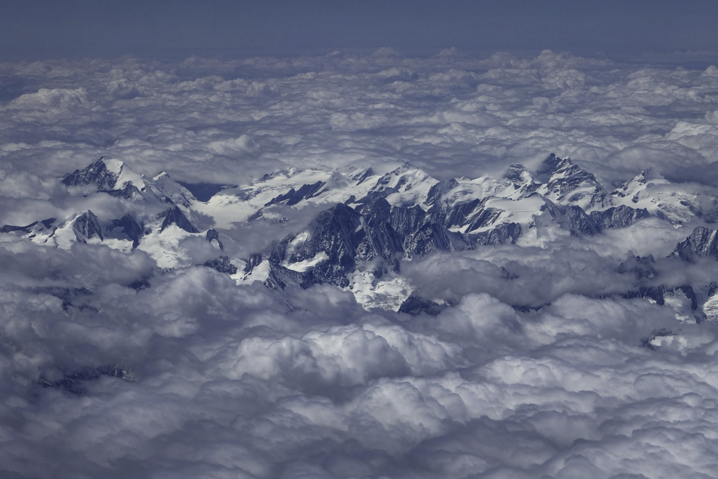 Mountains peeking through the clouds, on the flight from Zurich to Rome.