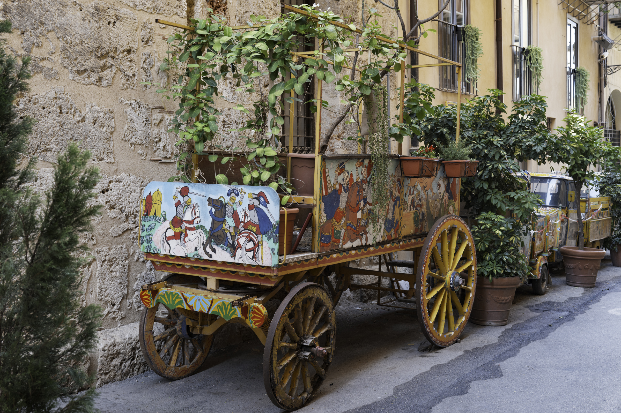 Old carts and vehicles now used as cute planter boxes, in Via Porta Carini.