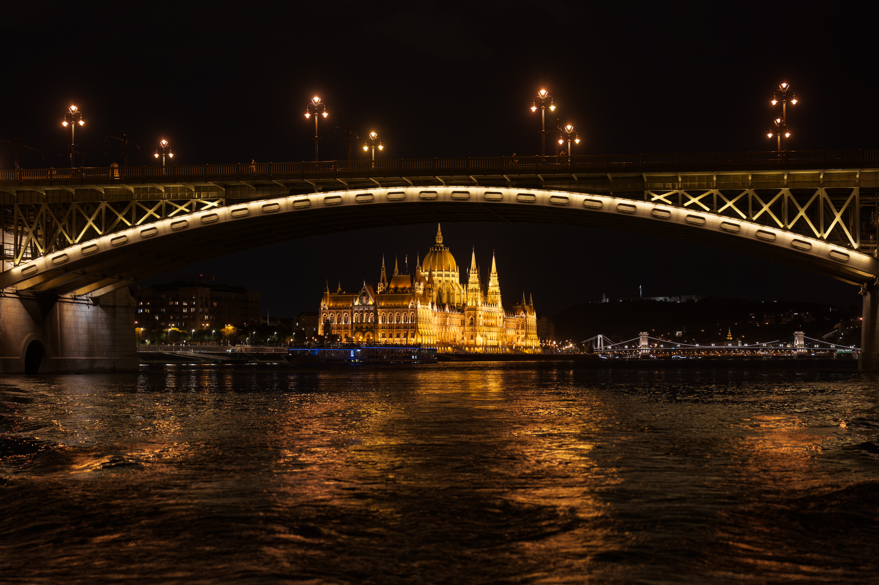 The Hungarian Parliament Building, viewed under the Margaret Bridge (with the Chain Bridge in the background) in Budapest.