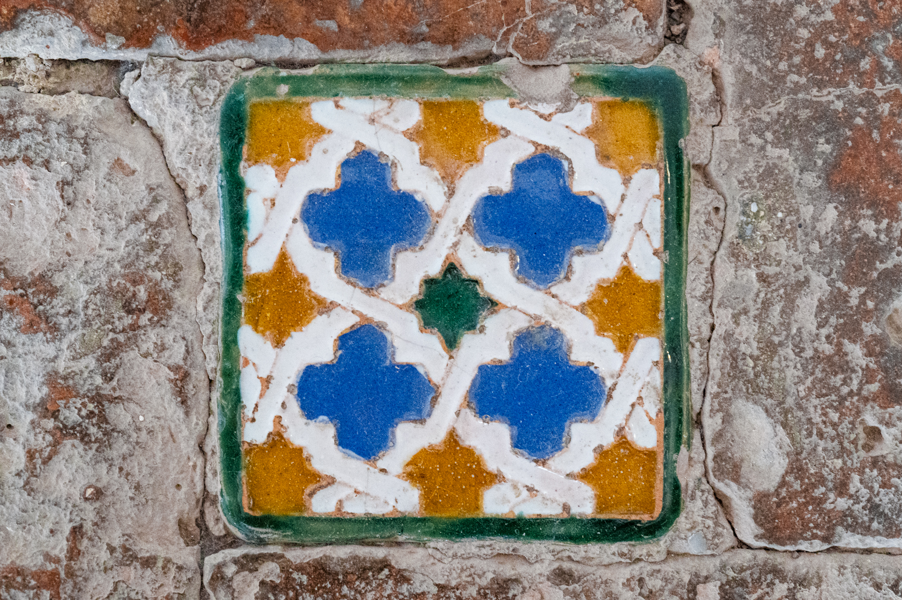 Moorish quatrefoil ceramic tile at the Nasrid Palaces in Granada.