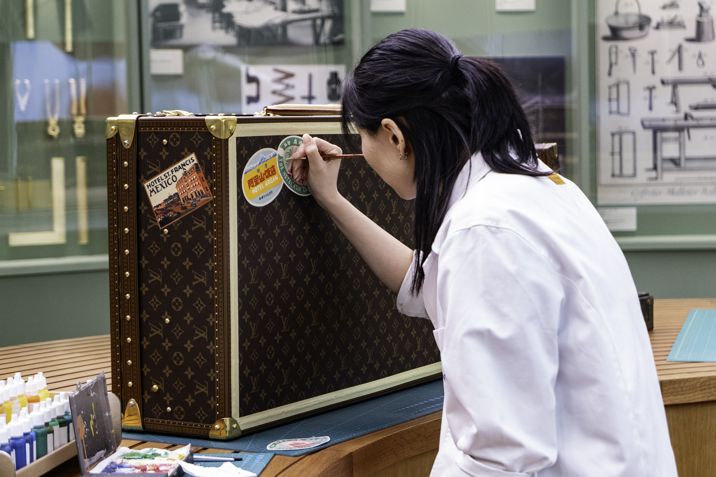 A steamer trunk being customised by an artist at the Louis Vuitton exhibition.
